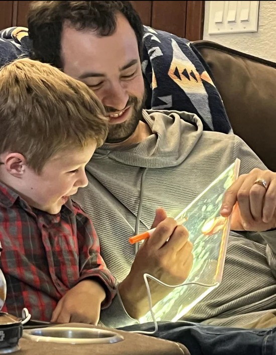 Noura's son practicing letters with dad on the KidoraX board